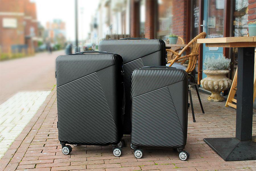 3 zwarte koffers op een terrasje op straat